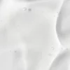 This image shows a close-up view of a creamy, viscous substance with small air bubbles. It is a homogenous and smooth texture with slight shadows.