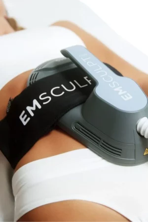 The image shows a person lying down with a device labeled "EMSCULPT" strapped around their midsection, presumably for muscle toning or body contouring.