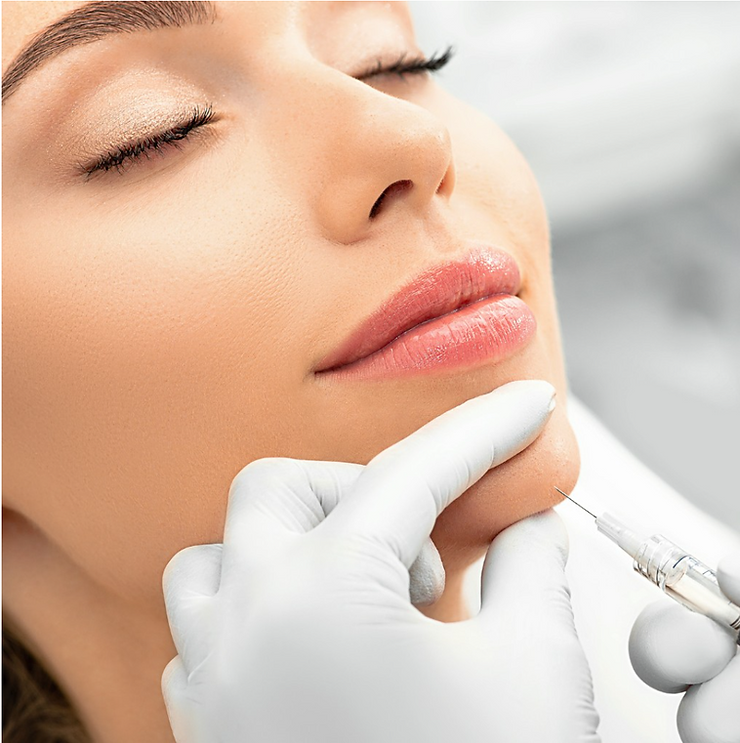 A person is receiving a cosmetic procedure with a needle on their chin, performed by a gloved hand in a clinical setting.